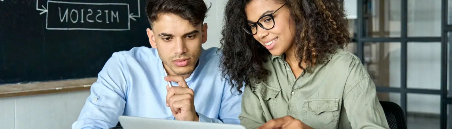 Colleagues diverse creative team group working at desk in office using laptop. un professeur et un élève entrain de chercher une entreprise pour son apprentissage : nos conseils